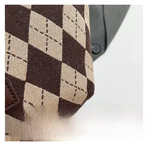 Detail of argyle knit pattern fabric and leather label on vintage crossbody bucket bag