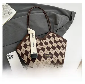 Close-up of the vintage brown checkered tote bag featuring a decorative logo ribbon detail