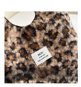 Close-up of leopard print plush tote bag showing soft woolly texture and woven label