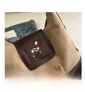 Detail shot of the khaki suede and brown leather tote bag with a cute puppy embroidery
