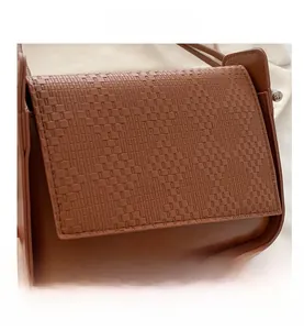 Detailed close-up of brown PU leather shoulder bag with woven texture and rectangle shape