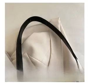Detail of the black leather shoulder strap and texture on this large tote bag