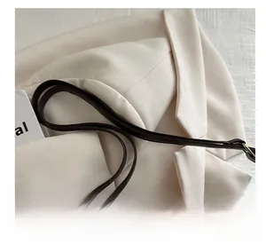 Détail du sac à bandoulière en laine à carreaux avec sangle en cuir et boucle dorée
