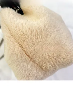 Détail de la texture douce en fausse fourrure beige et chaîne de ce sac seau d'hiver