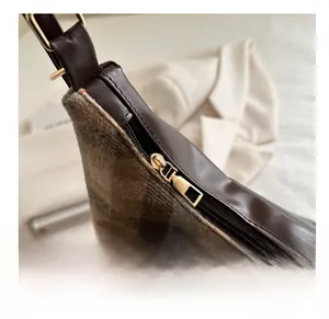 Détail d'un sac à carreaux vintage avec fermeture éclair en métal bronze lisse de qualité