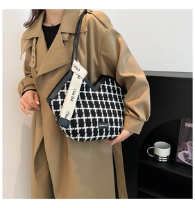Close-up of black and white checkered tweed tote bag with decorative brand ribbon detail