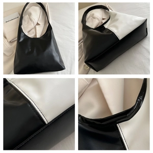 Macro details of stitching and side view of black and white color-block hobo bag