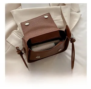 Detail view of the brown leather shoulder bag interior showing the magnetic flap and phone space