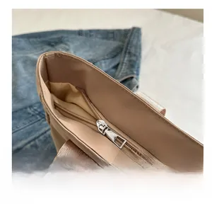 Detail of smooth metal zipper and premium fabric texture on beige tote handbag