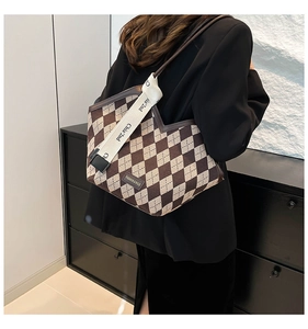Detail of the brown checkered tote bag with fashion tag and wide canvas shoulder strap