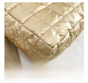 Close-up of champagne quilted tote bag showing high-quality stitching and glossy fabric