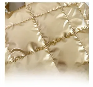 Detailed macro view of golden quilted fabric with elegant rhombic pattern on tote bag