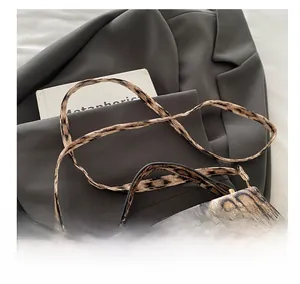 Sac bandoulière léopard chic sur blazer, montrant le détail de la sangle texturée