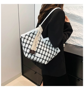 Detail view of the black and white plaid tweed tote bag with chic white leather trim strap