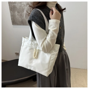 Close-up of white tote bag side pocket and woven rope zipper pulls on nylon fabric