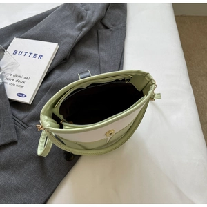 Internal view of mint green bucket bag showing zipper pocket and magnetic closure detail
