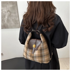 Vue détaillée du sac à dos vintage à carreaux avec rabat en cuir brun et logo doré chic