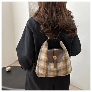 Gros plan du sac à dos vintage à carreaux avec rabat en cuir brun et boucle dorée N