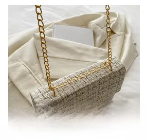 Close-up of beige tweed crossbody bag with gold metallic weave and chain strap