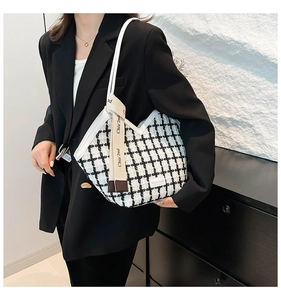 Close-up of black and white checkered tweed tote bag with chic decorative ribbon