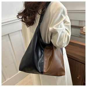 Side view of large bicolor patchwork tote bag worn by model in minimalist studio