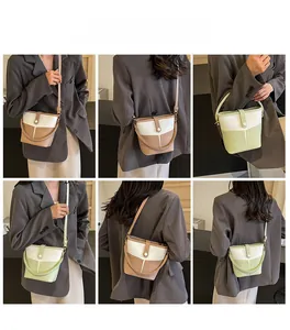 Detail view of stylish color-block bucket bags in light brown and green with adjustable straps