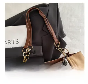 Détail d'un sac cabas en toile avec poignées en chaîne métallique et pendentif ours doux