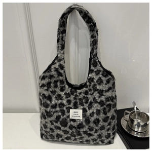 Detail of plush leopard print tote bag with soft faux fur texture and branded label