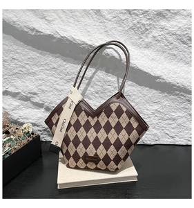 Detail of vintage plaid tote bag with V-shaped opening and brown leather shoulder straps