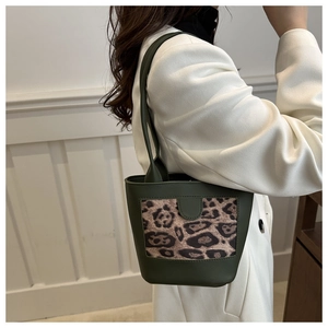 Detail of dark green bucket bag with leopard print panel and slender shoulder strap