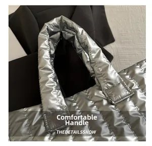 Gros plan détaillé de la poignée rembourrée d'un sac cabas argenté en duvet matelassé