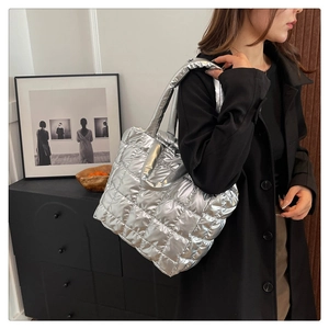 Detailed view of silver quilted tote bag featuring a metallic puffy design for winter