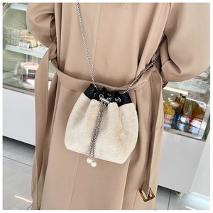 Détail d'un sac seau en peluche avec bandoulière chaîne et perles de serrage