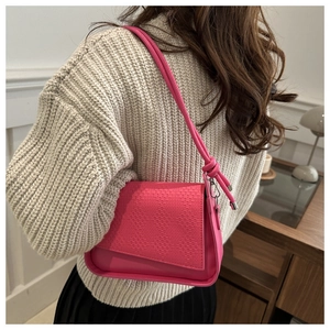 Detail of rose red PU leather shoulder bag featuring woven texture and knot strap decoration