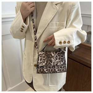 Détail du sac bandoulière léopard montrant la texture suédée et les boucles en métal