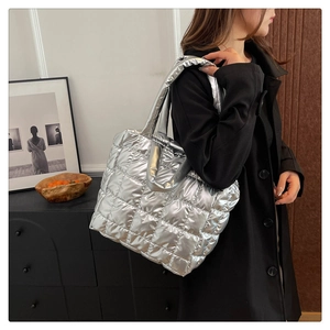 Detailed macro view of quilted silver metallic tote bag showing padded grid texture and shine