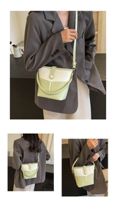 Three-way view of a two-tone bucket bag styled on a model in a grey blazer jacket
