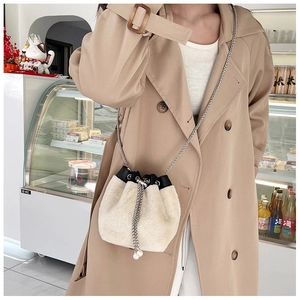 Détail du sac seau en fausse fourrure blanche avec perles et bandoulière chaîne