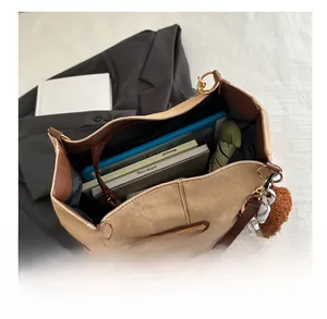 Détail du sac cabas en toile kaki avec bordure en cuir montrant une grande capacité