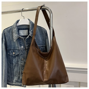 Detailed macro view of vintage brown PU leather hobo bag with vertical stitching decoration