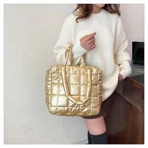 Detail of gold quilted tote bag with metallic finish and fluffy padded texture