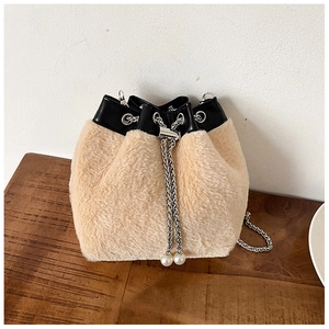 Vue détaillée du sac seau en peluche beige avec chaînes argentées et détails de perles