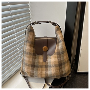 Détail du sac à carreaux en laine avec garniture en cuir et boucle dorée en forme de N