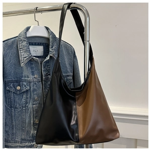 Detail of a large capacity faux leather tote bag with black and brown color blocking