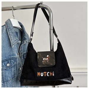 Macro detail of black vintage shoulder bag with puppy embroidery and matte leather texture