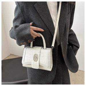 Vue détaillée du sac blanc à motif crocodile avec fermoir rotatif en métal argenté