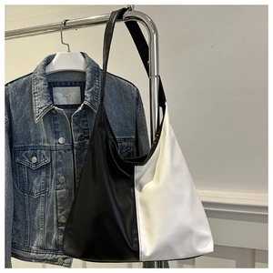 Detail of hobo tote bag featuring black and white contrast PU leather on a clothes hanger