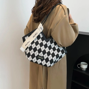 Retro black and white checkered canvas tote bag with wide strap worn by a female model
