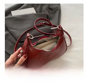 Top view of a burgundy half-moon crossbody bag showing internal storage for a smartphone