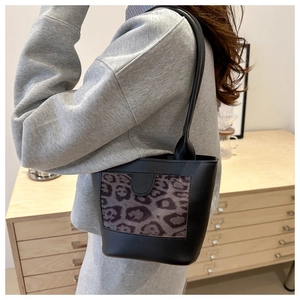 Detail showing leopard print shoulder bag with black leather and slim strap on model